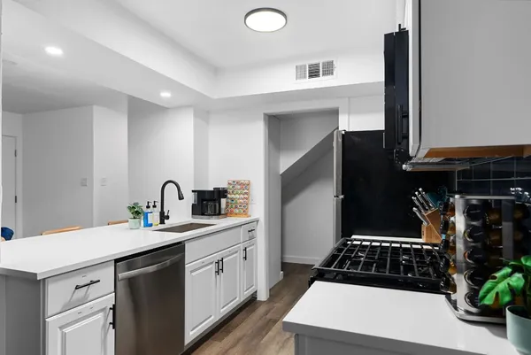 a kitchen with a sink a stove and cabinets