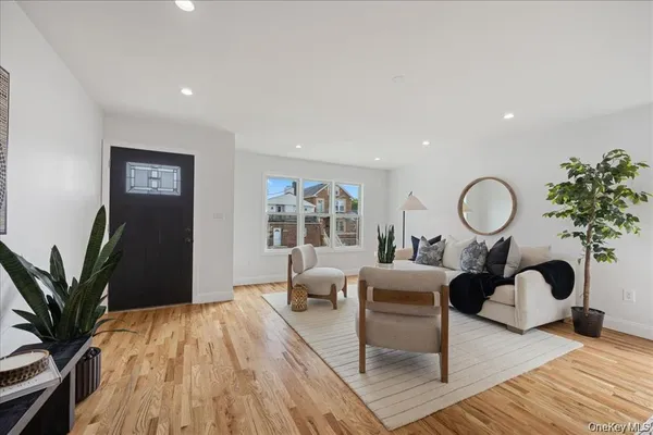 a living room with furniture potted plant and a large window