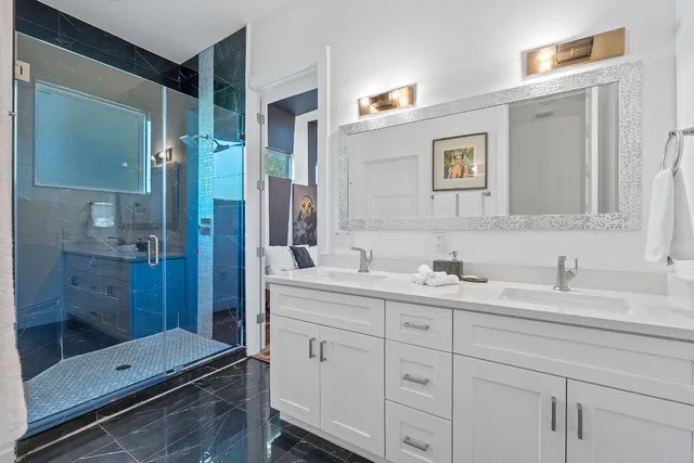 a en suite bathroom with a granite countertop sink mirror and shower