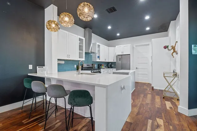 a kitchen with stainless steel appliances granite countertop a stove refrigerator and cabinets