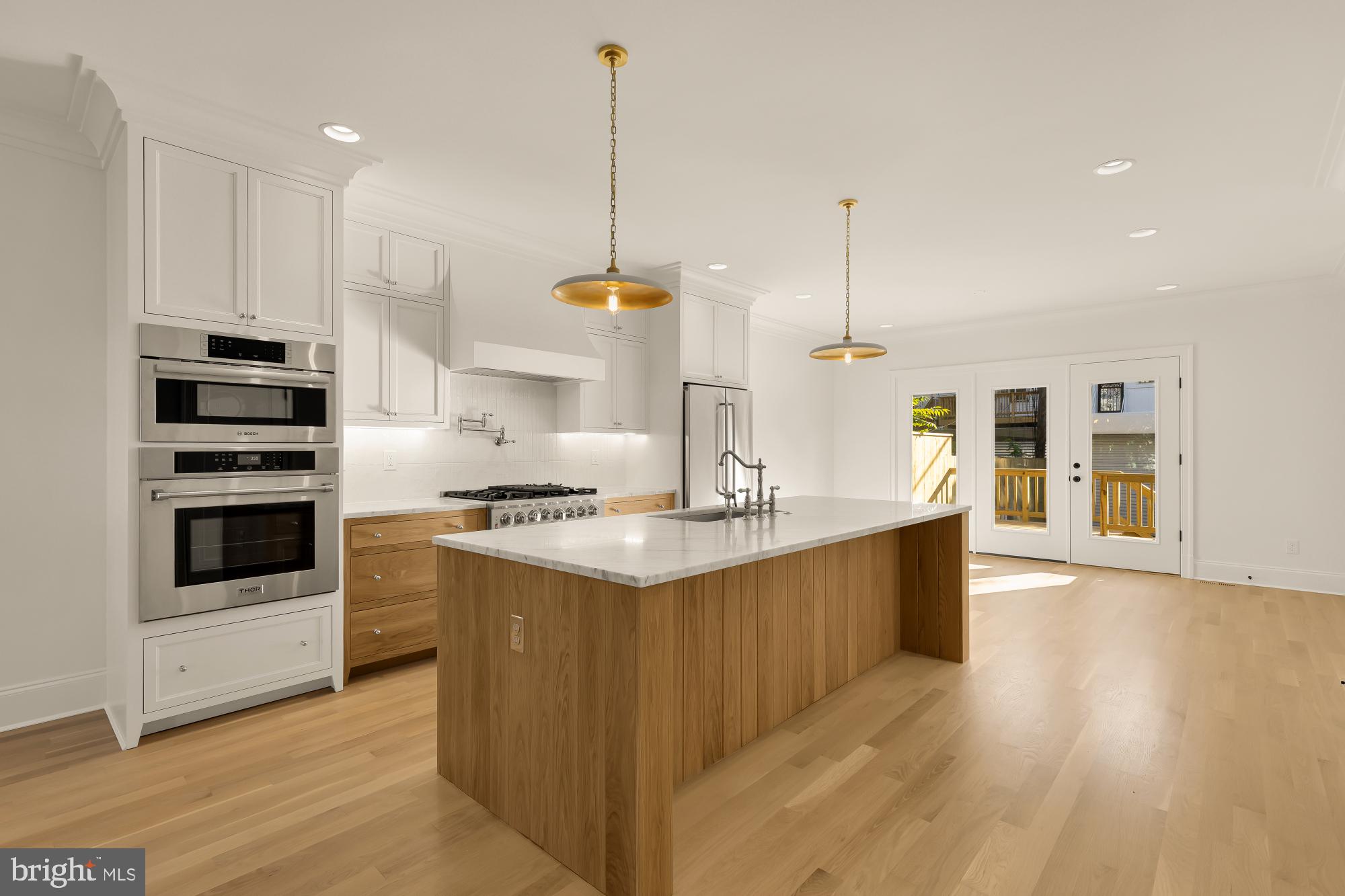 1412 Perry Place Northwest Washington, DC 20010 - Photo 13 of 52 a kitchen with stainless steel appliances kitchen island granite countertop a sink a stove and a wooden floors
