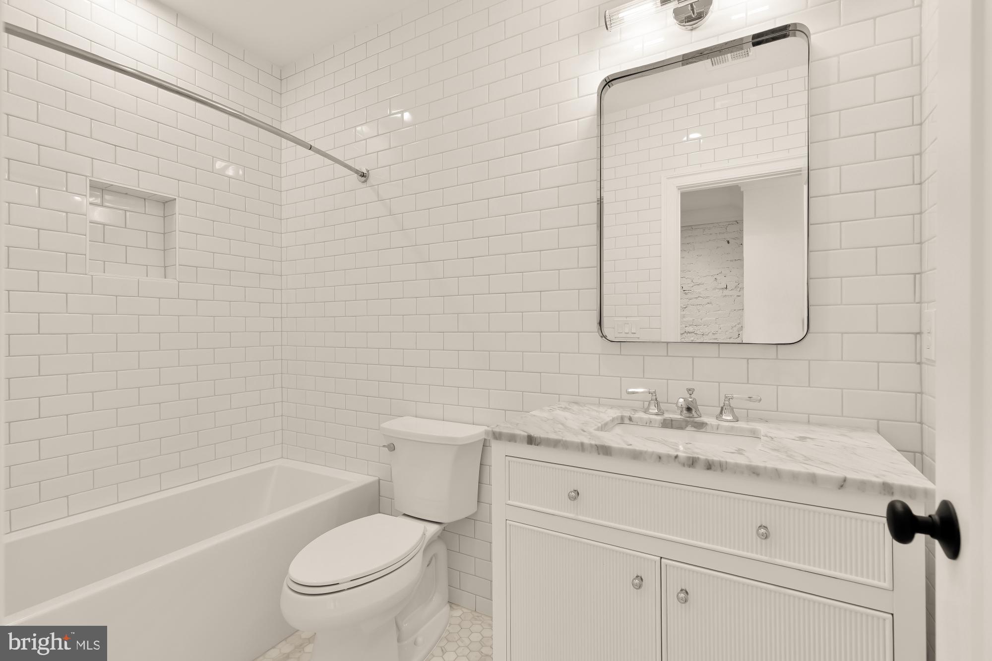 1412 Perry Place Northwest Washington, DC 20010 - Photo 32 of 52 a bathroom with a granite countertop toilet a sink and a bathtub