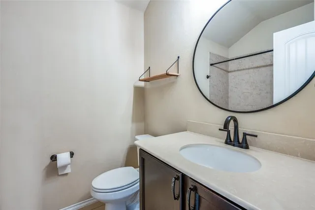 a bathroom with a sink a toilet and a mirror
