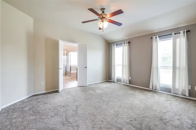 a view of a big room with windows and a chandelier fan