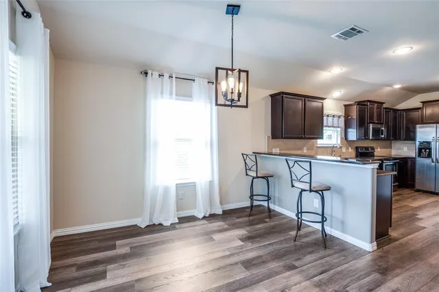 a open kitchen with stainless steel appliances granite countertop a refrigerator a stove top oven a sink and dishwasher