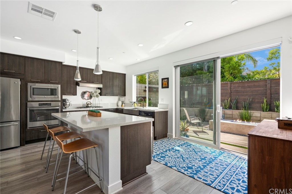 1267 Westreef Costa Mesa, CA 92627 - Photo 1 of 34 a kitchen with kitchen island a large counter top space appliances and a counter top space