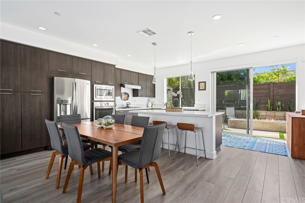 1267 Westreef Costa Mesa, CA 92627 - Photo 2 of 34 a dining room with stainless steel appliances granite countertop a dining table chairs and couches