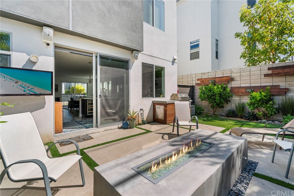 1267 Westreef Costa Mesa, CA 92627 - Photo 21 of 34 a view of a patio with table and chairs potted plants and floor to ceiling window