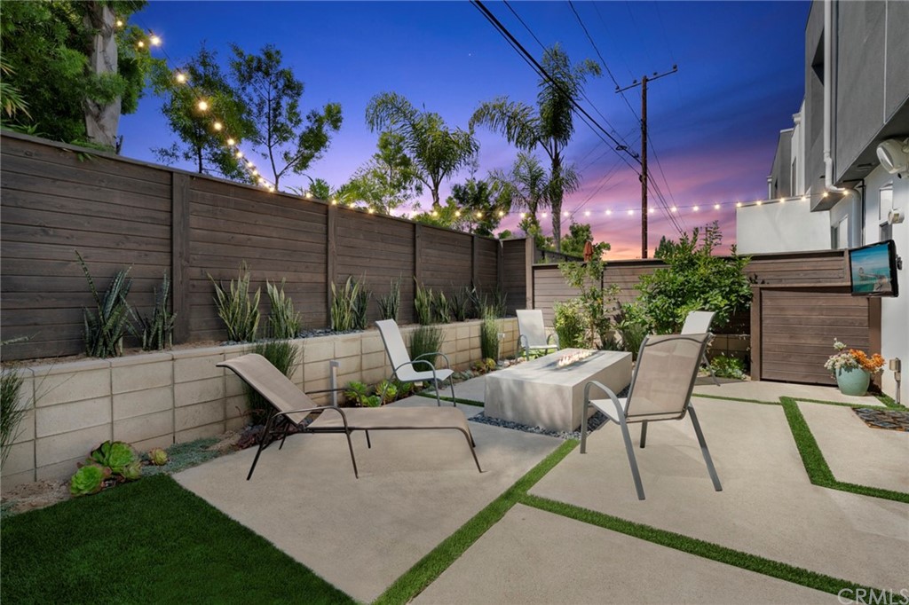 1267 Westreef Costa Mesa, CA 92627 - Photo 25 of 34 a view of a patio with table and chairs potted plants and a palm tree