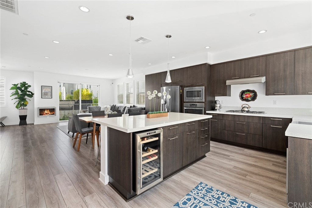 1267 Westreef Costa Mesa, CA 92627 - Photo 6 of 34 a kitchen with stainless steel appliances kitchen island granite countertop a stove top oven a sink a dining table and chairs