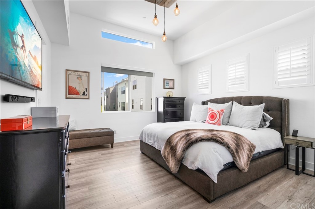 1267 Westreef Costa Mesa, CA 92627 - Photo 10 of 34 a large bedroom with a bed and a chandelier