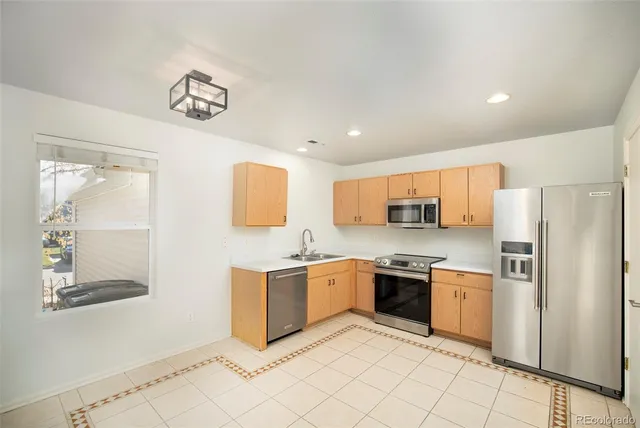 a kitchen with stainless steel appliances granite countertop a refrigerator and a stove top oven