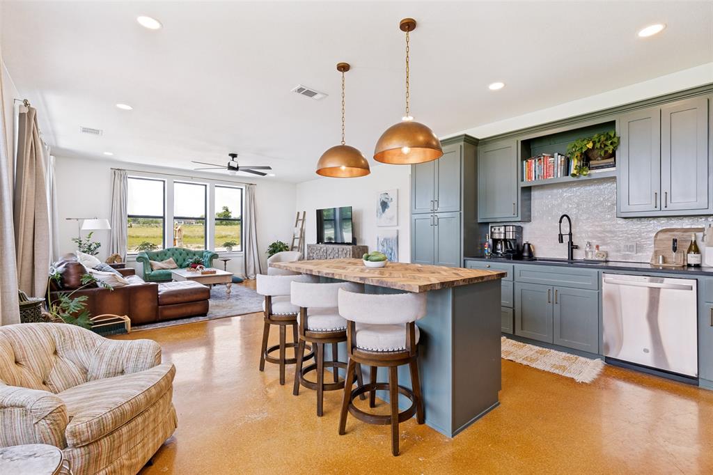 490 Private Road 4512 Decatur, TX 76234 - Photo 7 of 27 Open-concept living space featuring a spacious kitchen island with seating, pendant lighting, stainless steel appliances, and ample cabinetry