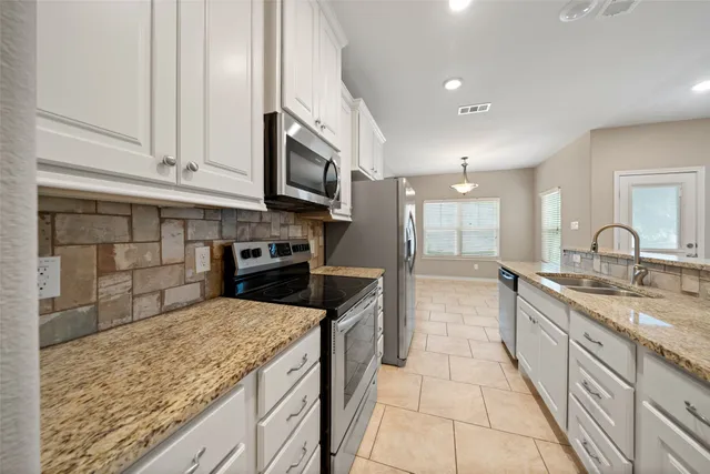 a kitchen with stainless steel appliances granite countertop a sink a microwave and stove