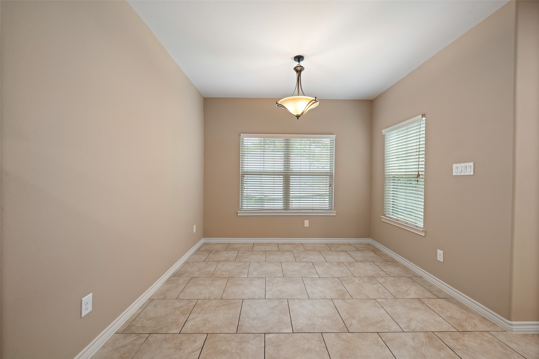 1413 East April Villa, Unit B Conroe, TX 77356 - Photo 15 of 33 an empty room with windows and chandelier fan
