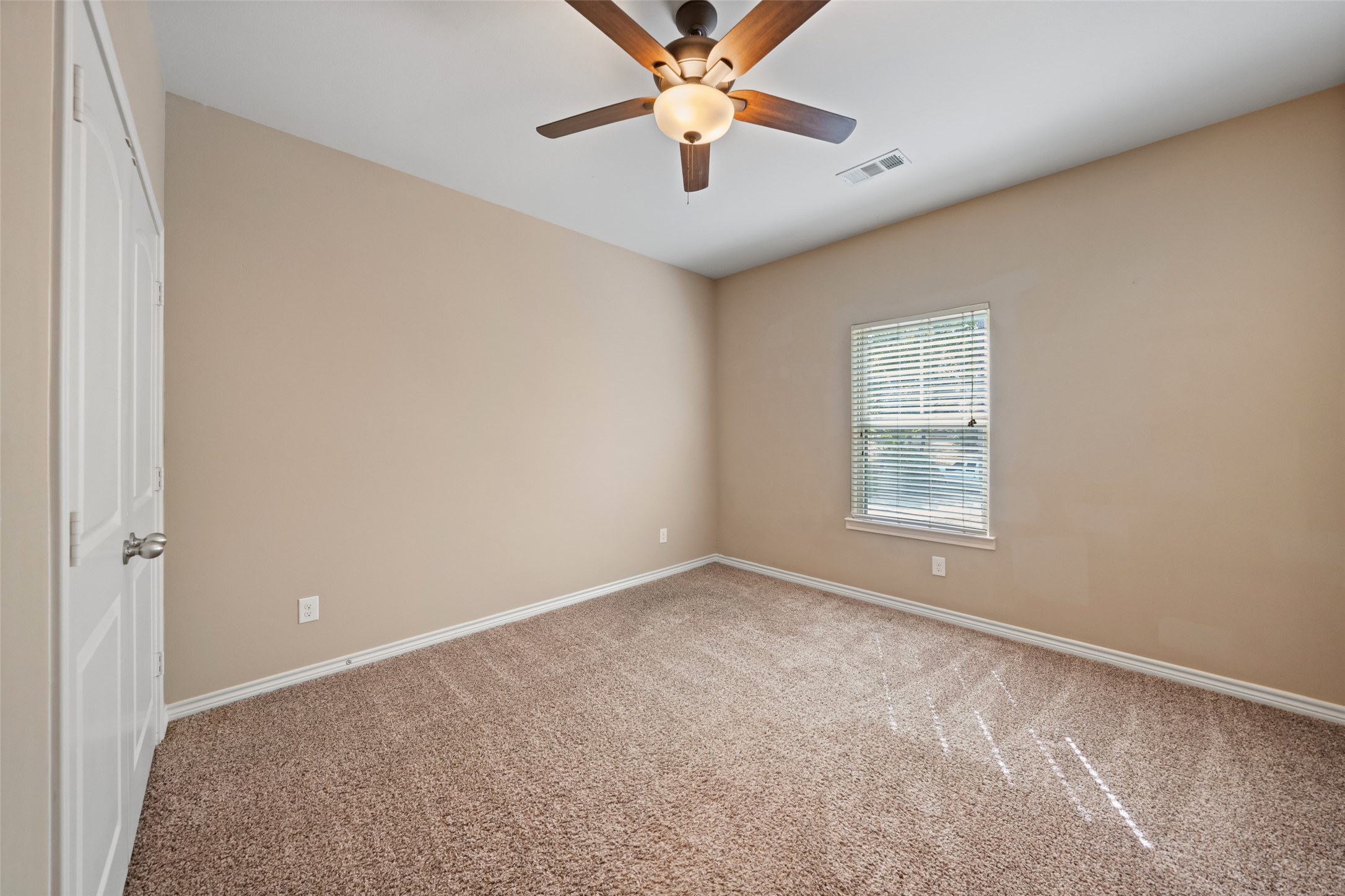 1413 East April Villa, Unit B Conroe, TX 77356 - Photo 16 of 33 an empty room with windows and fan