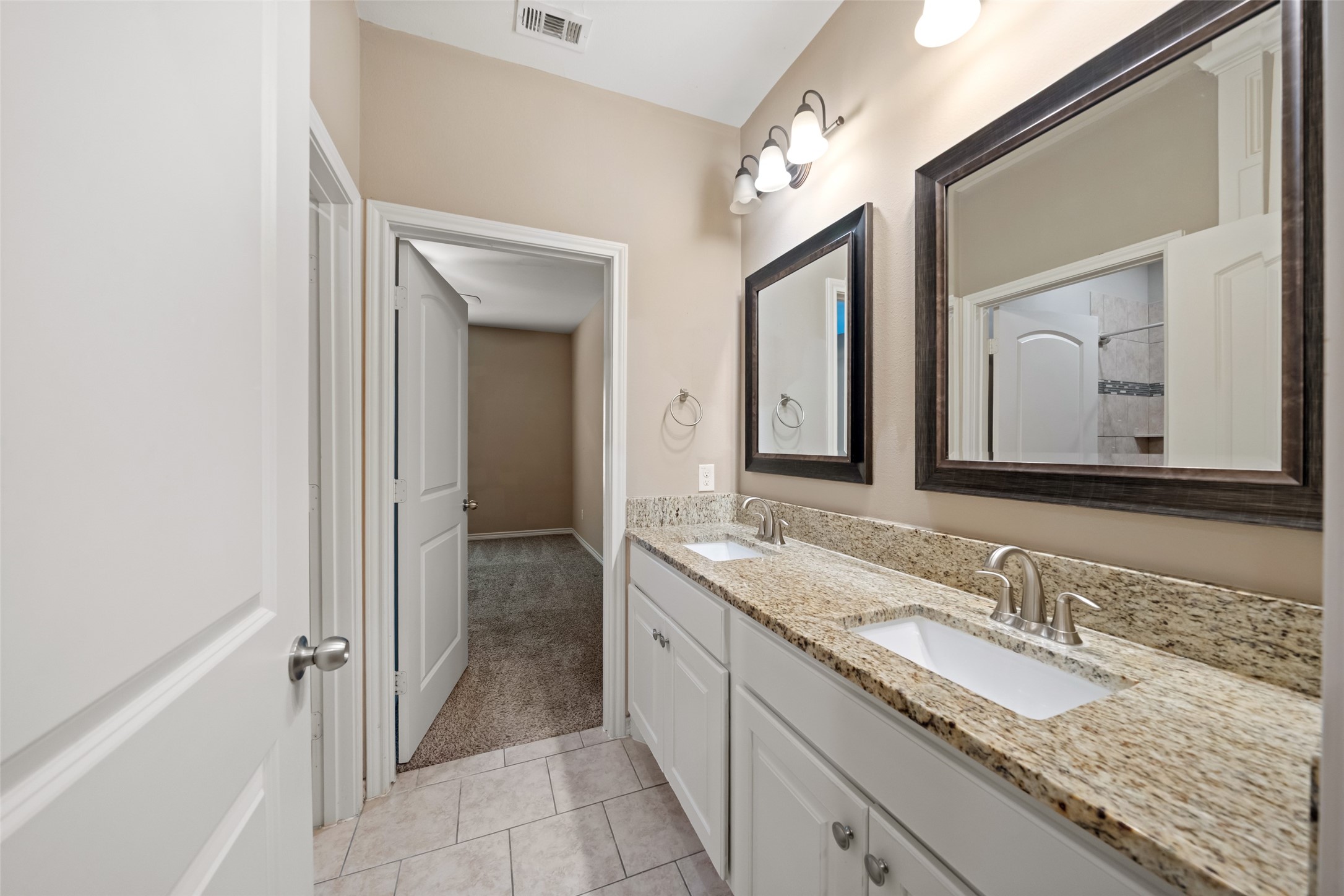 1413 East April Villa, Unit B Conroe, TX 77356 - Photo 17 of 33 a bathroom with a granite countertop sink double and mirror