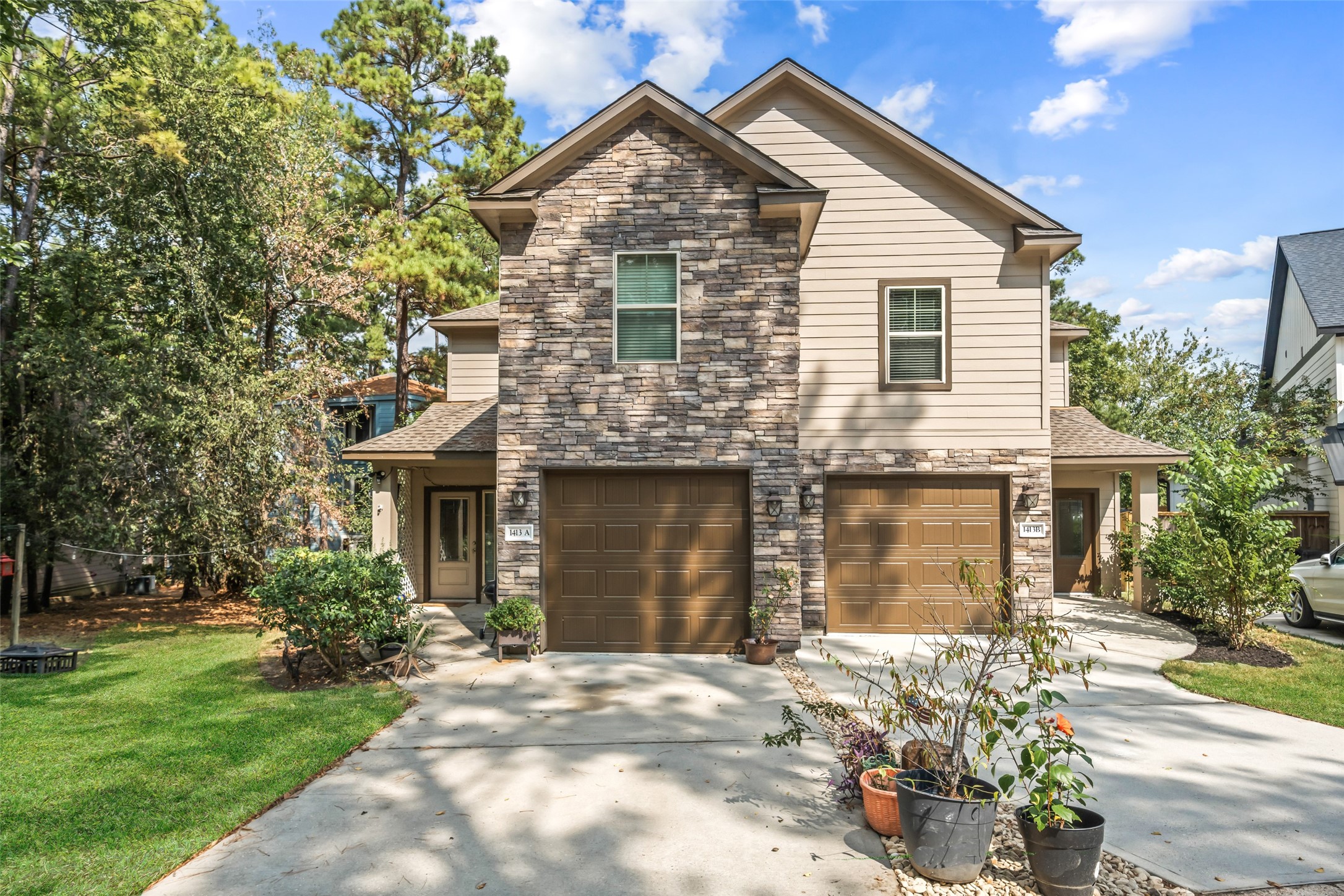 1413 East April Villa, Unit B Conroe, TX 77356 - Photo 2 of 33 a front view of a house with a yard and garage