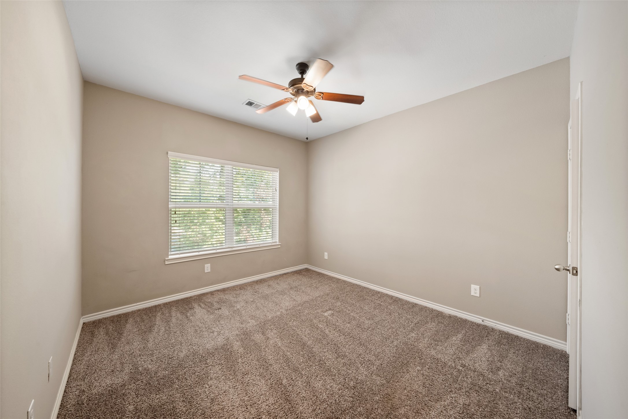 1413 East April Villa, Unit B Conroe, TX 77356 - Photo 21 of 33 an empty room with windows and ceiling fan