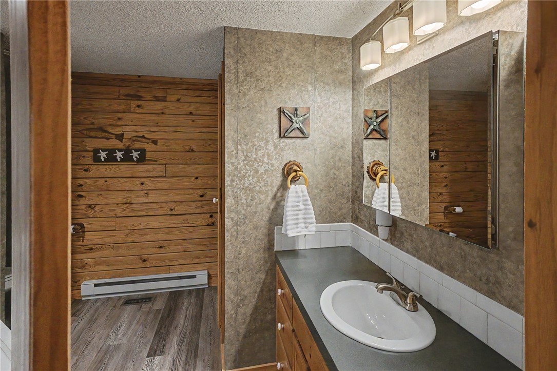 21019 Carter Road West Fork, AR 72774 - Photo 34 of 49 Bathroom vanity featuring an integrated sink with brushed nickel faucet, a medicine cabinet with mirrored doors, and a four-light fixture