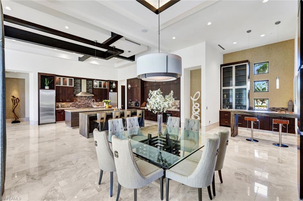 4431 Wayside Drive Naples, FL 34119 - Photo 11 of 49 a dining room with stainless steel appliances kitchen island granite countertop a table and chairs