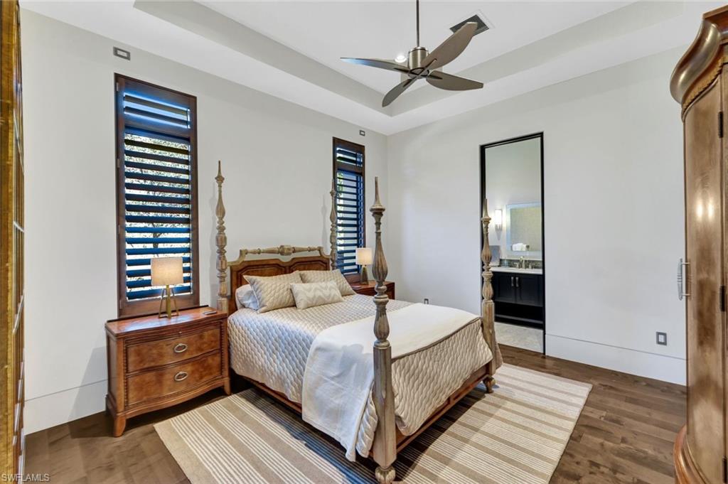 4431 Wayside Drive Naples, FL 34119 - Photo 35 of 49 a bedroom with a bed and a chandelier