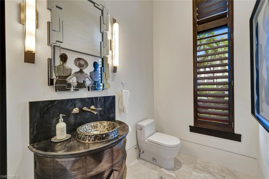 4431 Wayside Drive Naples, FL 34119 - Photo 37 of 49 a bathroom with a toilet and a painting on the wall