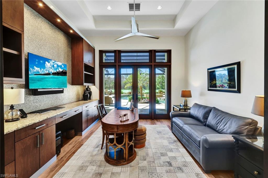 4431 Wayside Drive Naples, FL 34119 - Photo 38 of 49 a living room with furniture a flat screen tv and floor to ceiling window