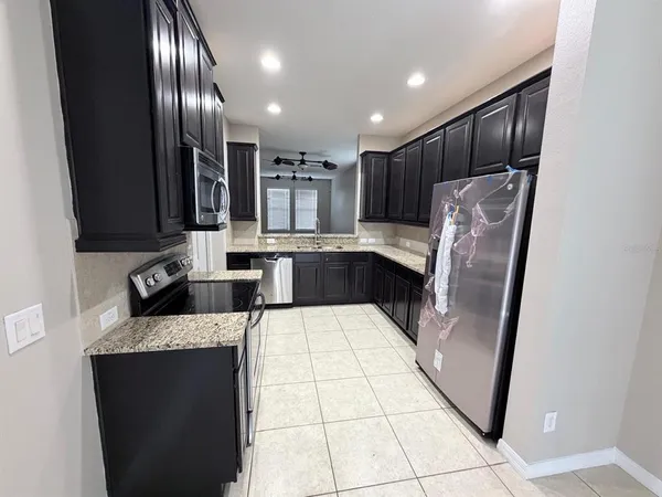 a large kitchen with a large counter top appliances and cabinets