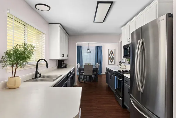 a kitchen with stainless steel appliances granite countertop a sink dishwasher and cabinets with wooden floor