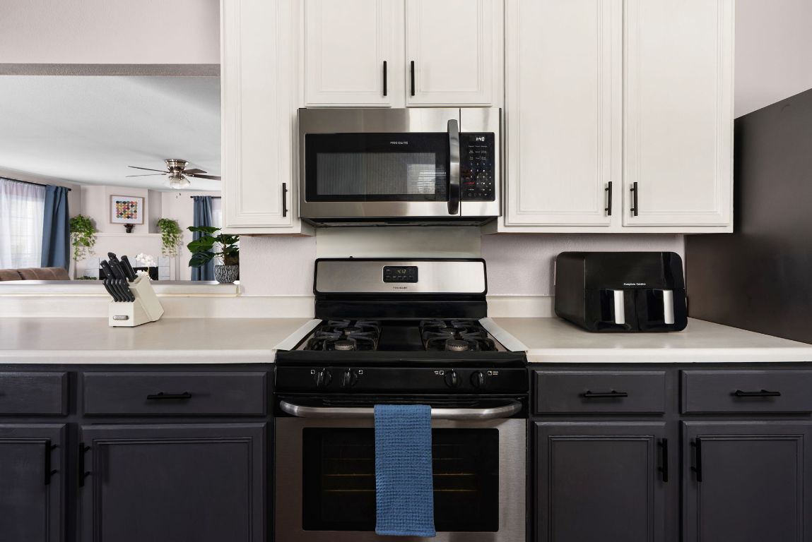 7906 Briarton Drive Austin, TX 78747 - Photo 14 of 38 a kitchen with stainless steel appliances granite countertop a sink stove and microwave