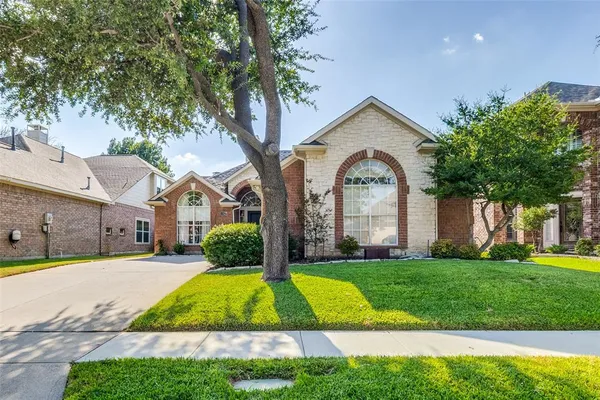 a view of a house with a big yard plants and large trees