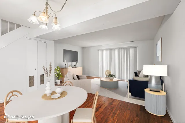 a view of a dining room with furniture a chandelier and wooden floor