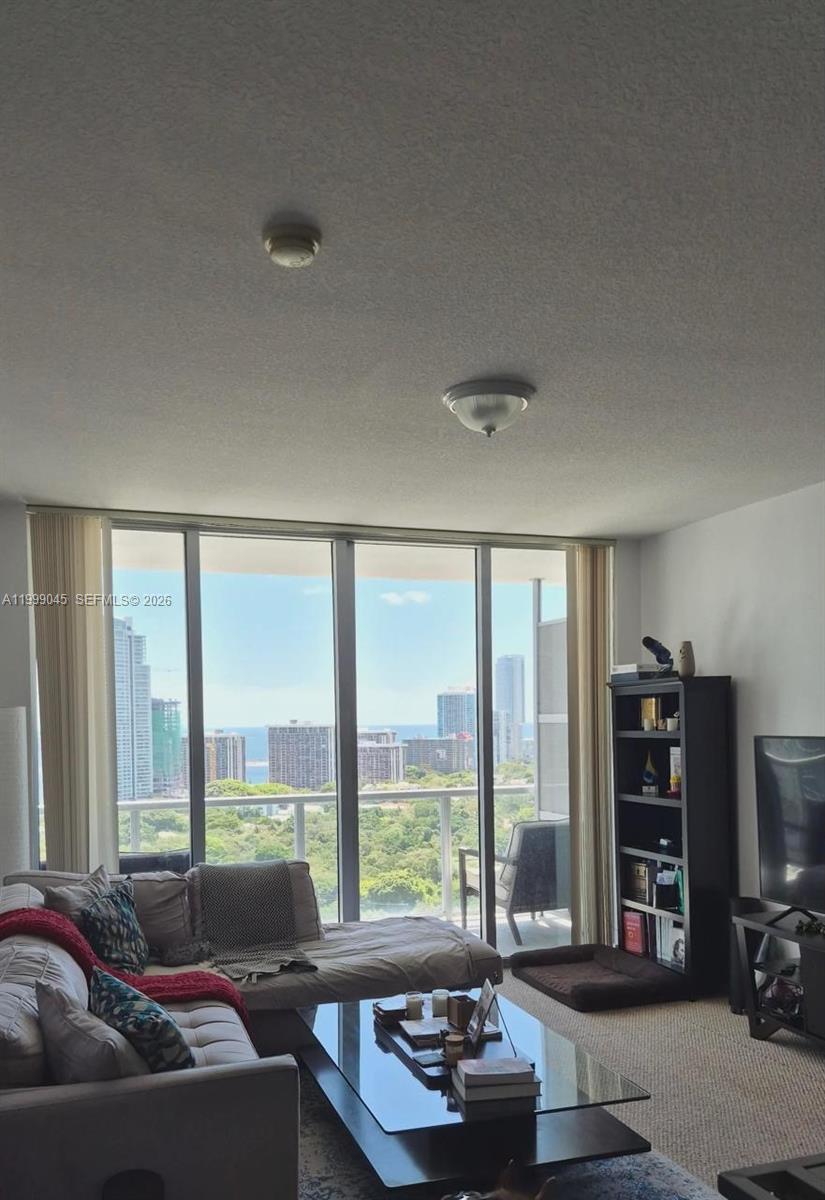 79 Southwest 12th Street, Unit 2702S Miami, FL 33130 - Photo 3 of 9 a living room with furniture and large windows