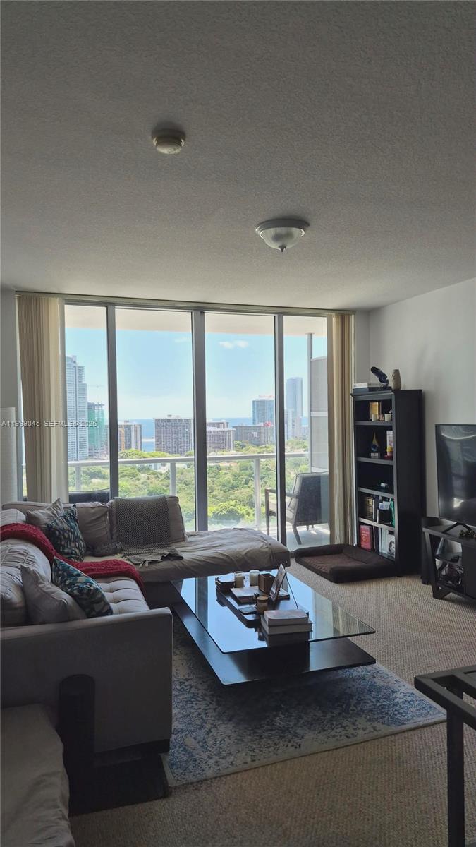 79 Southwest 12th Street, Unit 2702S Miami, FL 33130 - Photo 5 of 9 a living room with furniture and floor to ceiling windows