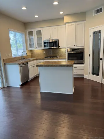 a kitchen with stainless steel appliances granite countertop a stove a sink and a microwave