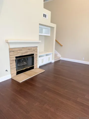 a living room with wooden floors and a fireplace