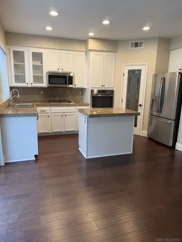 a kitchen with stainless steel appliances granite countertop a refrigerator sink and stove