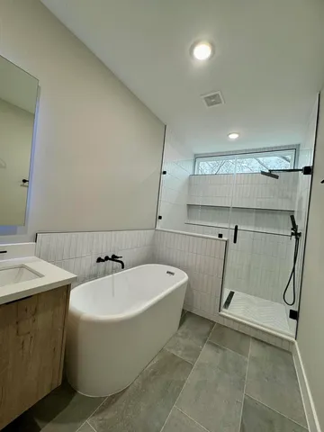 a spacious bathroom with a sink a mirror and a bath tub