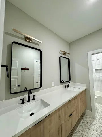 a bathroom with double vanity sinks and a mirror