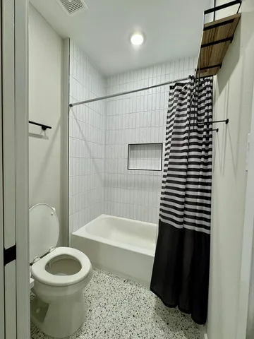 a bathroom with a toilet and a shower