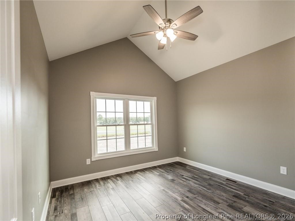 1102 West Carthage Road Lumberton, NC 28360 - Photo 27 of 41 an empty room with wooden floor ceiling fan and windows