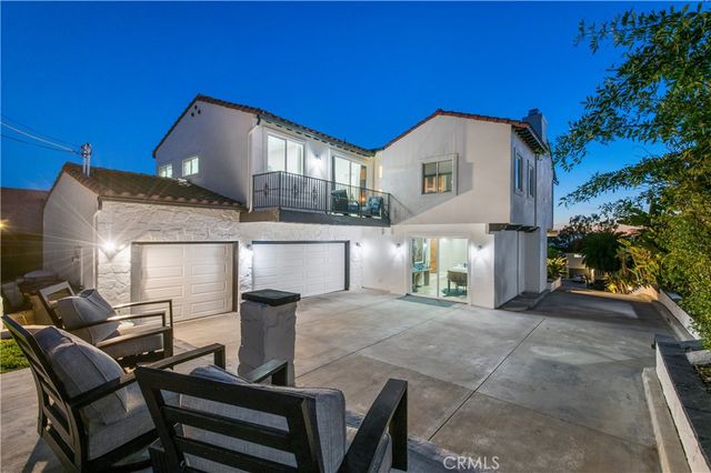 a view of a house with backyard and sitting area