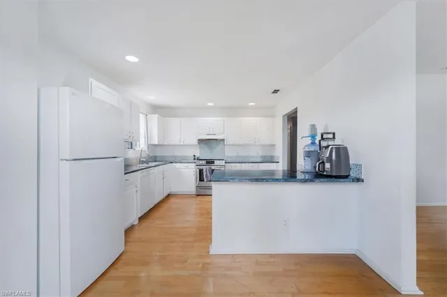 a large white kitchen with cabinets