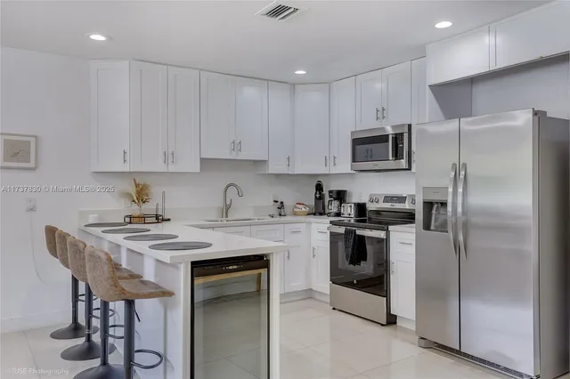 a kitchen with stainless steel appliances granite countertop a stove a refrigerator and a microwave