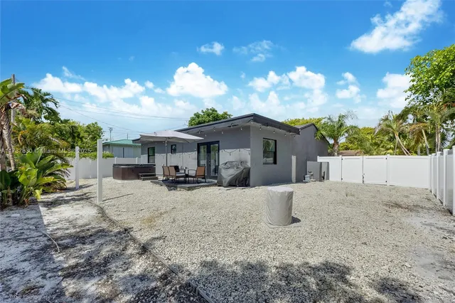 a view of a house with backyard and sitting area
