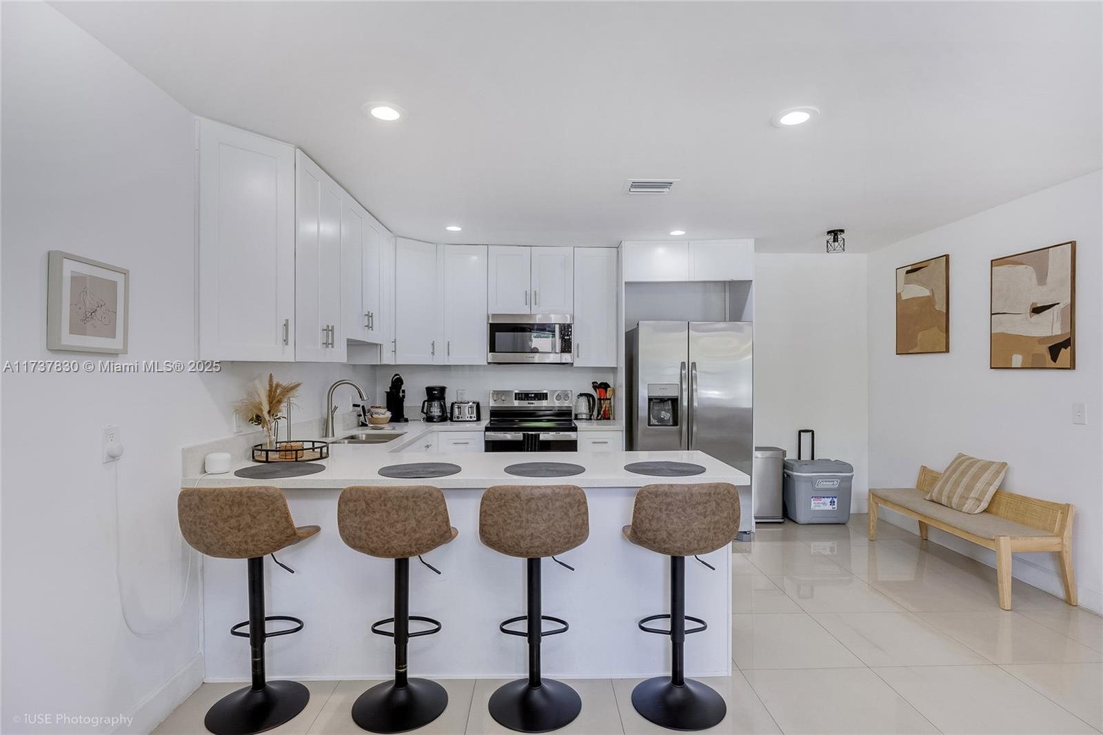 1401 Southwest 3rd Avenue Dania Beach, FL 33004 - Photo 4 of 15 a kitchen with stainless steel appliances granite countertop a stove a sink a refrigerator white cabinets and chairs
