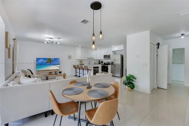 a kitchen with stainless steel appliances kitchen island granite countertop a dining table and chairs