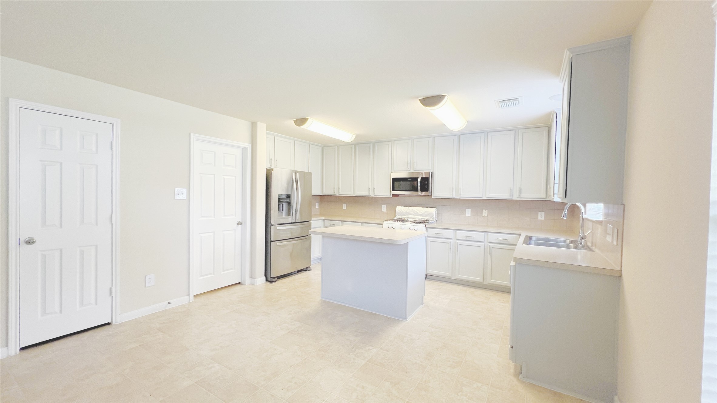 21338 Bella Mountain Drive Spring, TX 77379 - Photo 4 of 33 a kitchen with white cabinets and white appliances