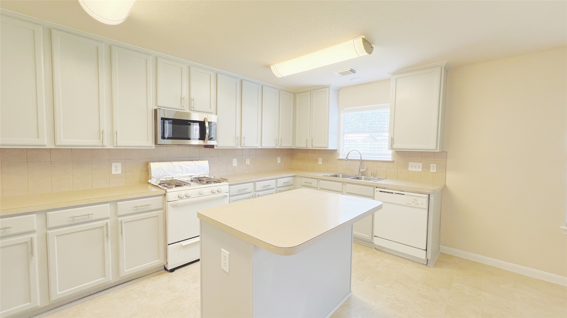 21338 Bella Mountain Drive Spring, TX 77379 - Photo 7 of 33 a kitchen with white cabinets and white appliances